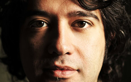 Close-up portrait of Turkish composer Erdem Helvacioglu, highlighting his focused gaze and expressive features.
