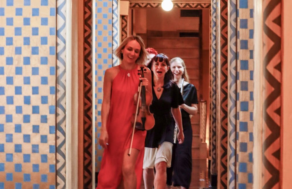 Musicians walk off the stage at First Plymouth Church smiling after the final concert of the 2022 Nebraska Crossroads Music Festival in Lincoln