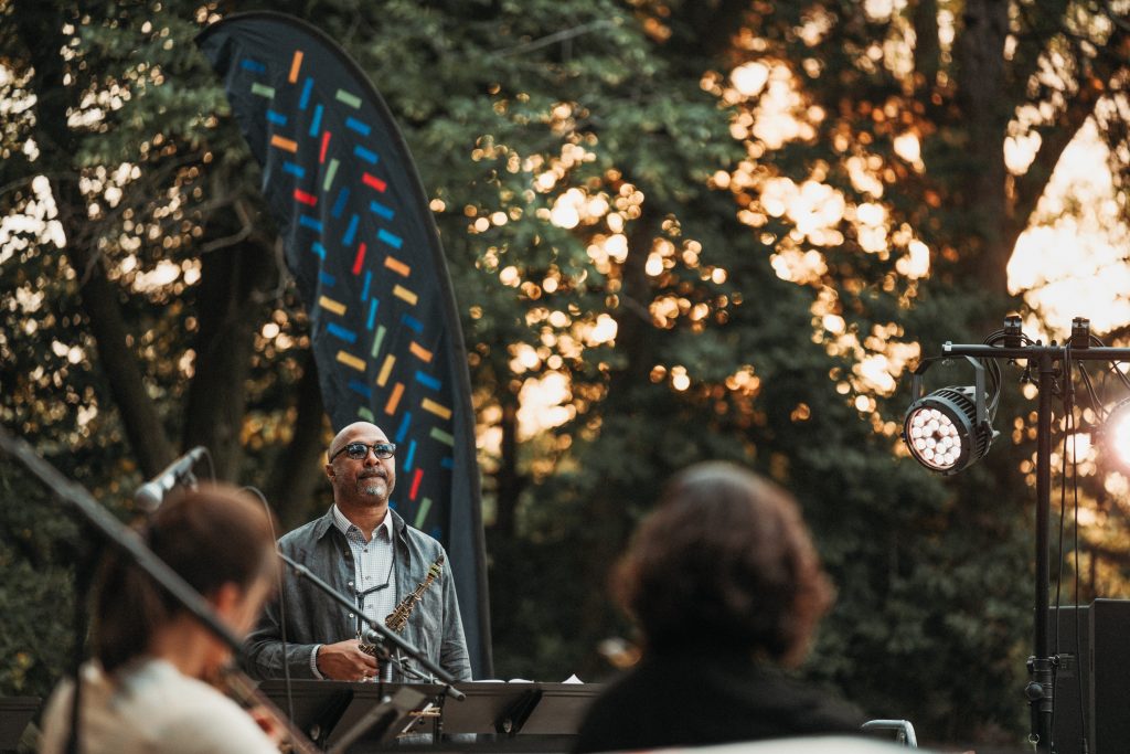 Saxophonist Ron Blake pauses for a moment of contemplation as the sun sets during the 2024 Lincoln Showcase at Antelope Park in Lincoln.