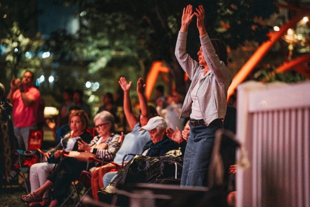 Audience members raise their hands and enjoy the music at the 2023 Nebraska Crossroads Music Festival at Gene Leahy Mall in Omaha