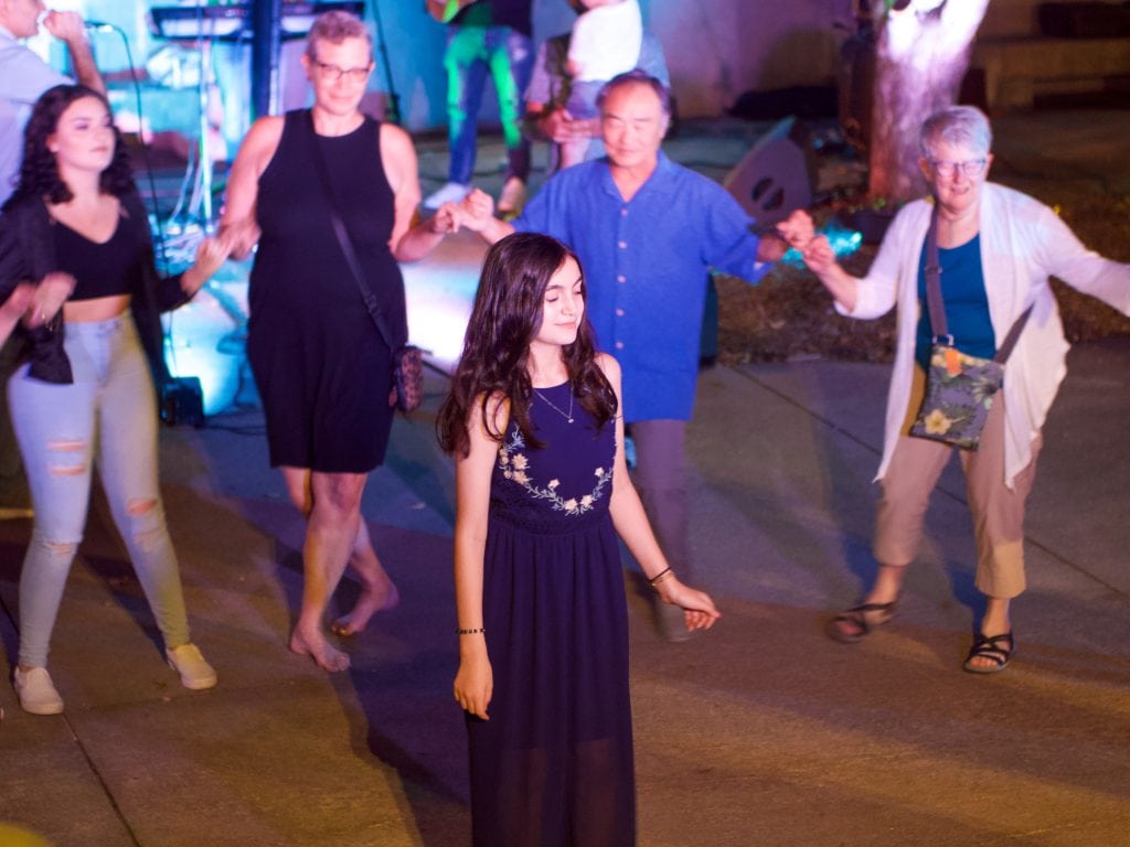 Community members join in a Yezidi dance circle during a Golden Studio performance at the 2022 Nebraska Crossroads Music Festival